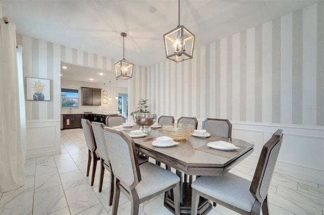 1536 Maidstone Ct, Davenport, FL 33896 - dining room with a decorative wall, wainscoting, marble finish floor, wallpapered walls, and a notable chandelier