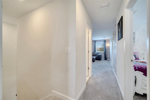 hallway featuring light colored carpet