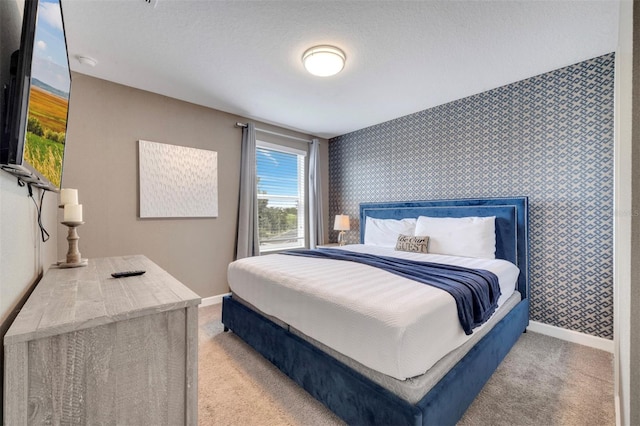 bedroom with light carpet and a textured ceiling