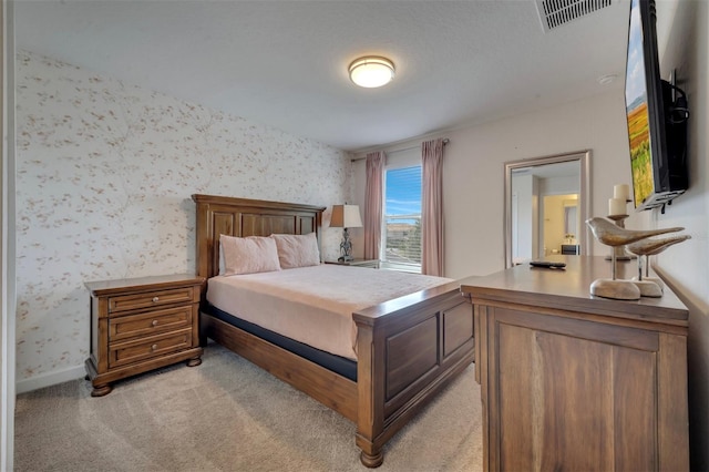 bedroom with light carpet and a textured ceiling