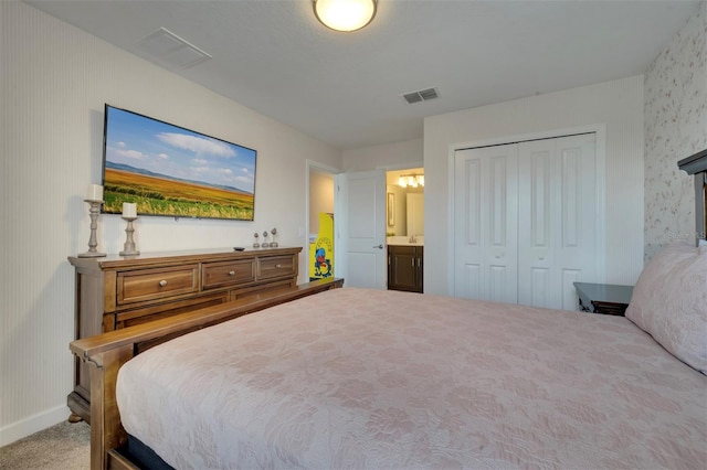 bedroom with connected bathroom, a closet, and carpet flooring