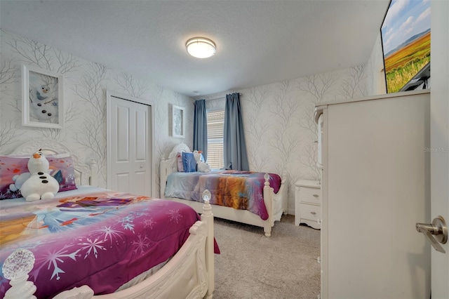 carpeted bedroom featuring a textured ceiling and a closet