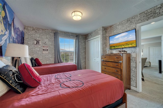 carpeted bedroom with a closet and a textured ceiling