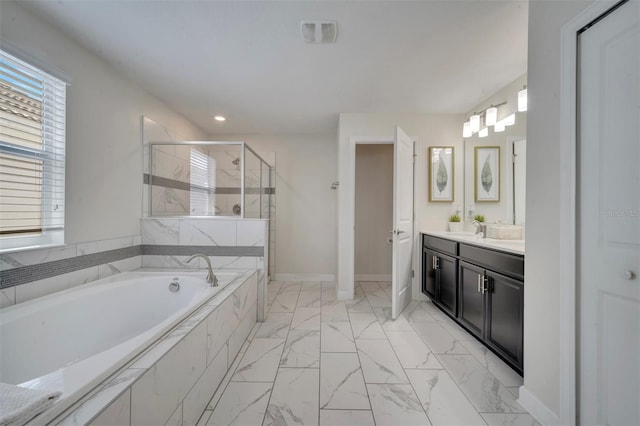 bathroom with a wealth of natural light, vanity, and separate shower and tub