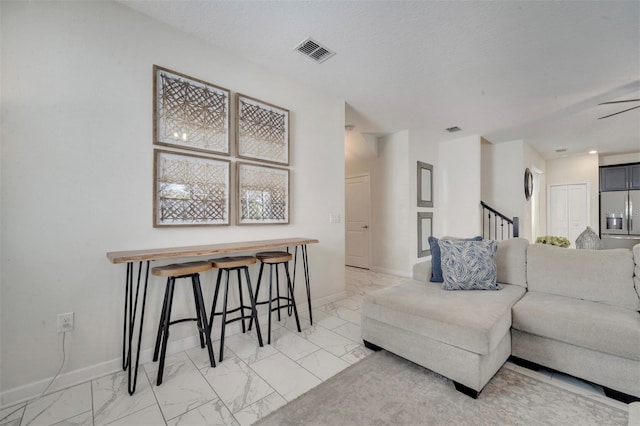 living room featuring a textured ceiling and ceiling fan