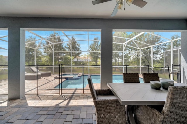 exterior space featuring glass enclosure, an in ground hot tub, and a patio