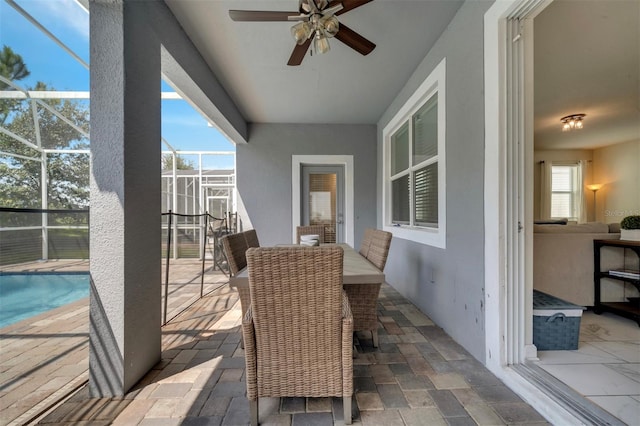 view of patio featuring glass enclosure and ceiling fan