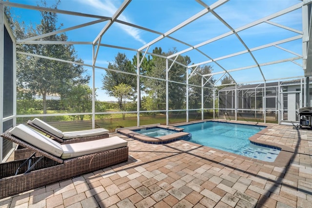 view of swimming pool with glass enclosure, an in ground hot tub, a grill, and a patio area