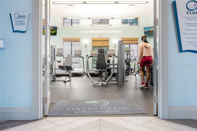 exercise room featuring a towering ceiling