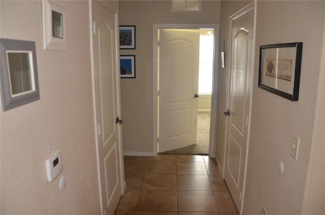 hall with dark tile patterned flooring