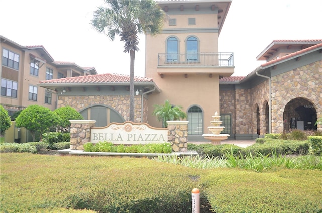 view of front of property with a front yard and a balcony