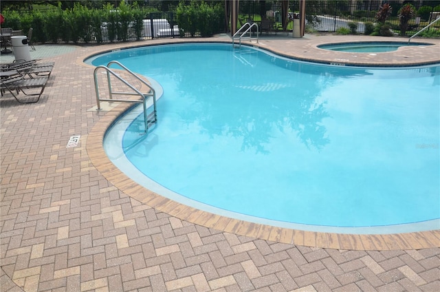 view of swimming pool with a patio and a community hot tub