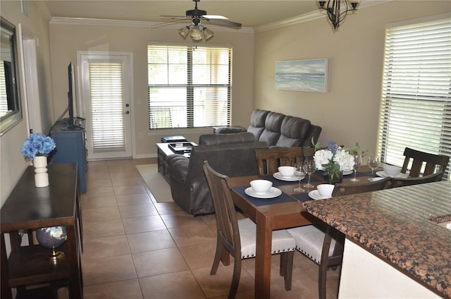 tiled dining room with ornamental molding and ceiling fan