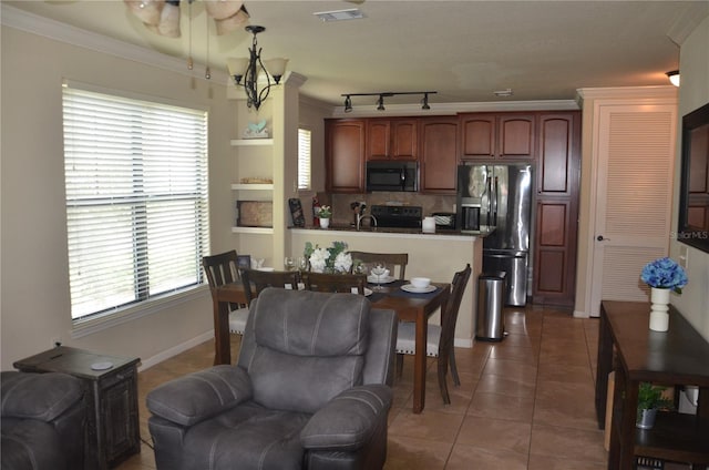 kitchen featuring a healthy amount of sunlight, black appliances, ornamental molding, and dark tile patterned flooring