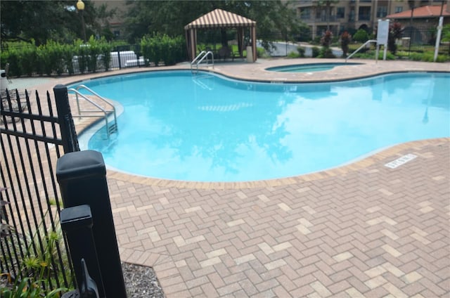 view of pool with a gazebo, a patio area, and a community hot tub