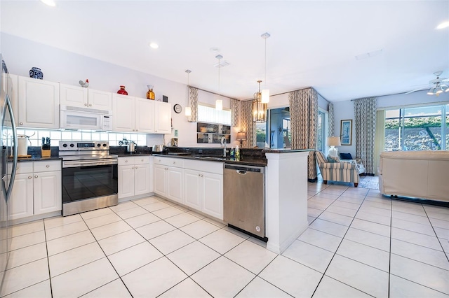 kitchen with ceiling fan, hanging light fixtures, kitchen peninsula, white cabinetry, and stainless steel appliances