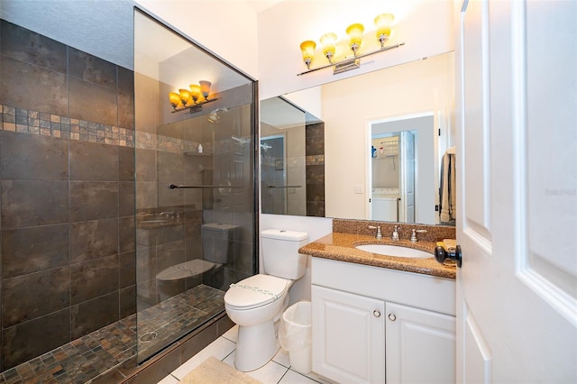 bathroom featuring a tile shower, tile patterned floors, vanity, and toilet