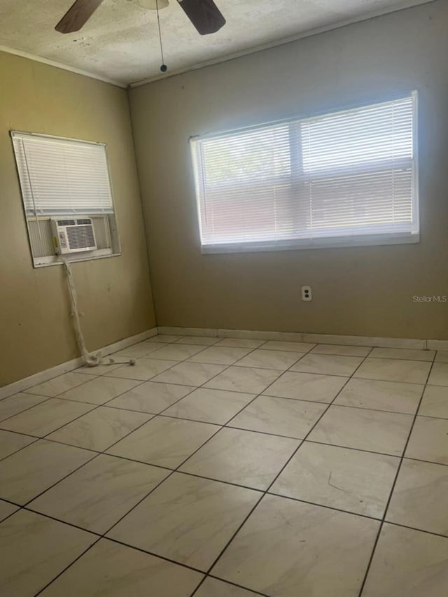 empty room with cooling unit, ceiling fan, light tile patterned floors, and a textured ceiling