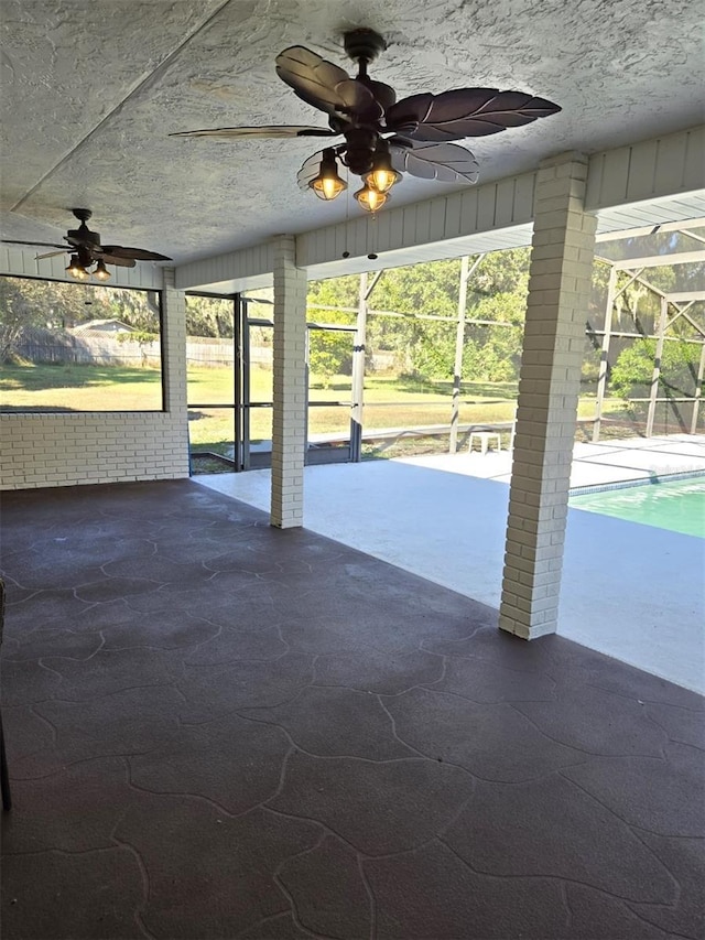 unfurnished sunroom featuring ceiling fan