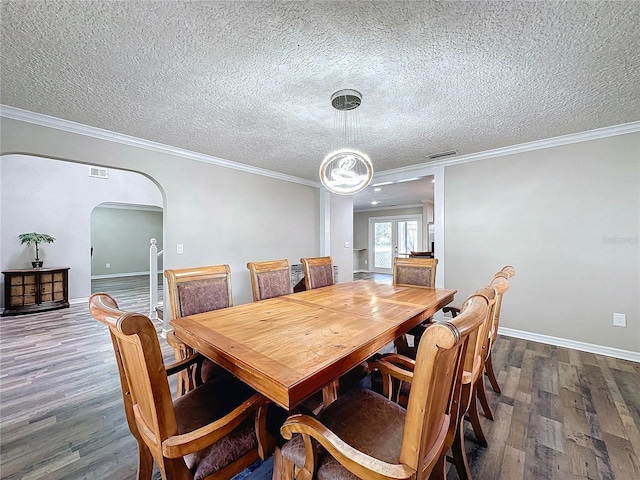 dining room featuring a textured ceiling, dark hardwood / wood-style flooring, and crown molding