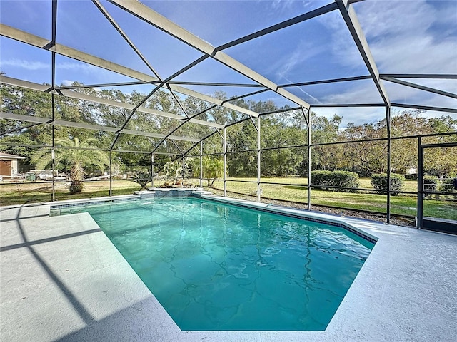 view of pool with glass enclosure, a yard, and a patio