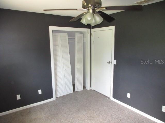 unfurnished bedroom featuring baseboards, a closet, ceiling fan, and carpet flooring