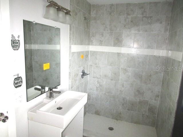 full bathroom featuring vanity and tiled shower