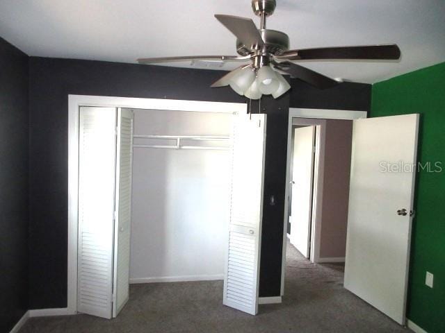 unfurnished bedroom with baseboards, a closet, and carpet flooring