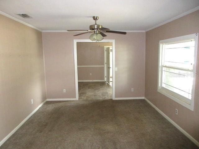 unfurnished room featuring ceiling fan, dark carpet, and ornamental molding