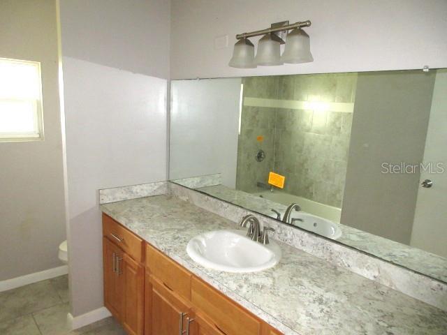 full bathroom featuring bathtub / shower combination, tile patterned floors, vanity, and toilet