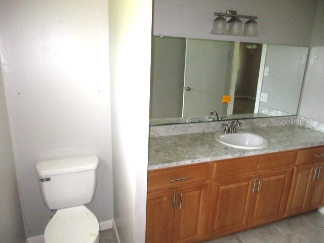 bathroom featuring tile patterned floors, vanity, and toilet