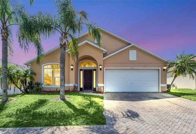 view of front of home featuring a garage and a lawn