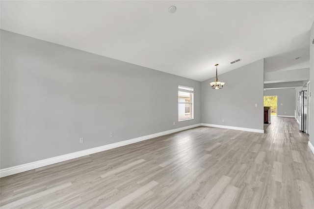 unfurnished living room with an inviting chandelier, light hardwood / wood-style floors, and lofted ceiling