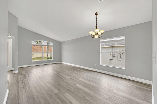 interior space featuring lofted ceiling, an inviting chandelier, and hardwood / wood-style flooring