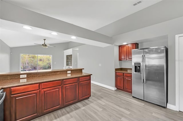 kitchen featuring ceiling fan, light hardwood / wood-style flooring, stainless steel appliances, dark stone counters, and vaulted ceiling