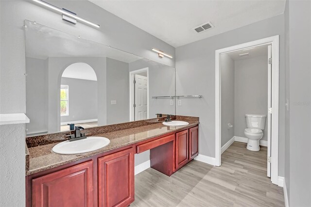 bathroom featuring hardwood / wood-style flooring, vanity, and toilet