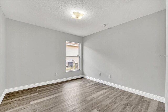 spare room featuring a textured ceiling and hardwood / wood-style floors