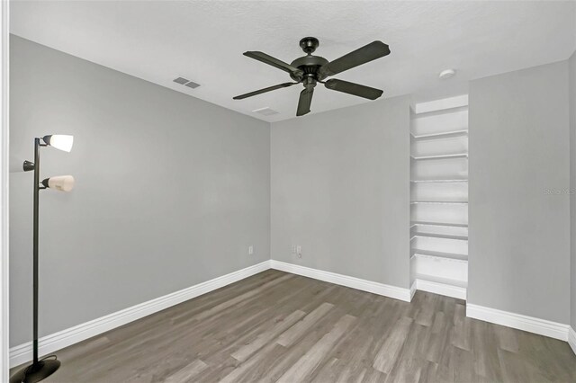 spare room with ceiling fan, hardwood / wood-style flooring, and a textured ceiling