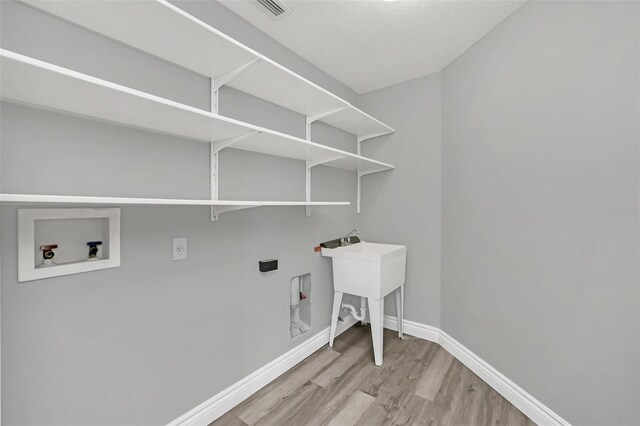 washroom with washer hookup and light hardwood / wood-style floors