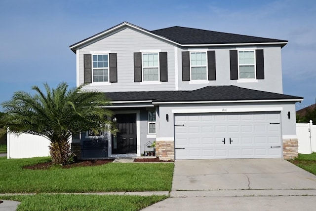 view of front of property featuring a front yard and a garage