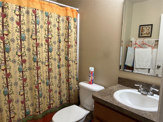 bathroom with curtained shower, vanity, and toilet