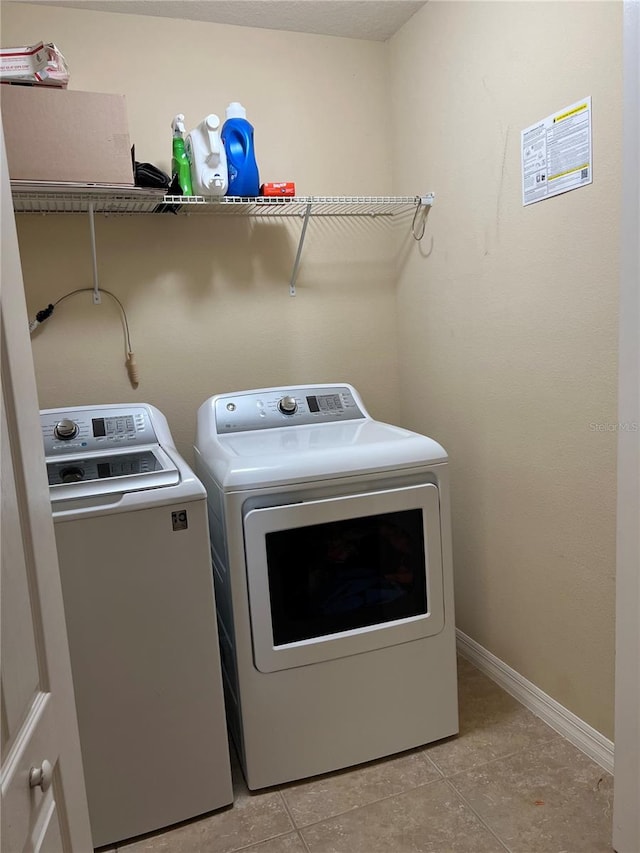 laundry area featuring light tile patterned flooring and washer and dryer