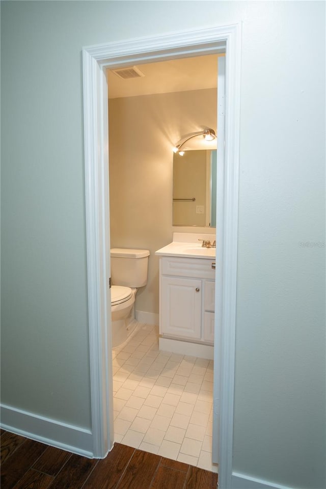 bathroom featuring hardwood / wood-style flooring, vanity, and toilet