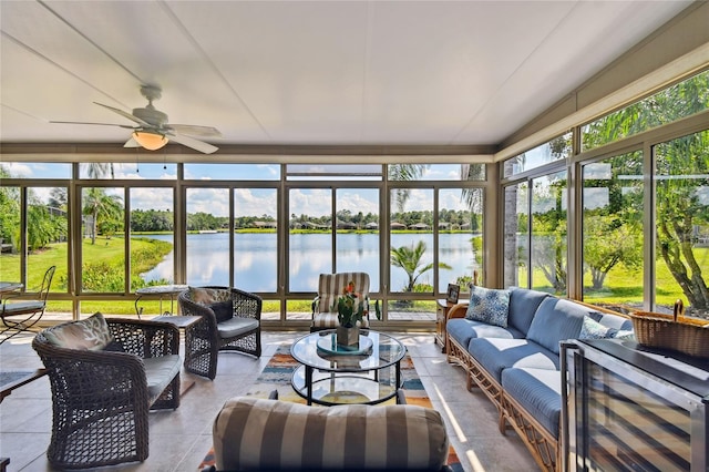 sunroom with ceiling fan and a water view