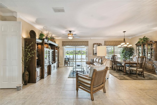 tiled living room with ceiling fan with notable chandelier and ornamental molding