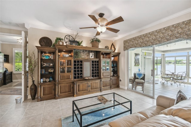 living room featuring ornamental molding, ceiling fan, light tile patterned floors, and a healthy amount of sunlight