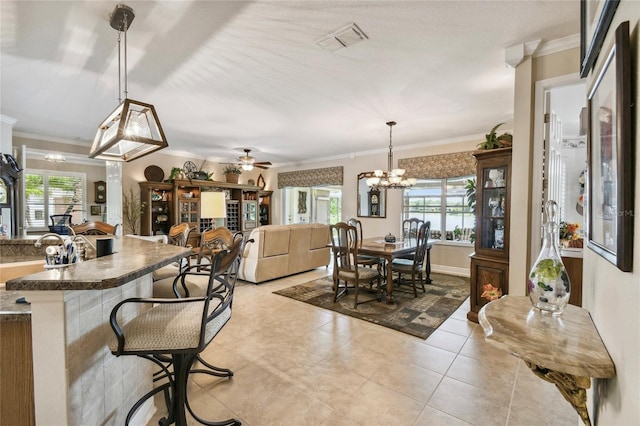 kitchen featuring ceiling fan with notable chandelier, pendant lighting, and ornamental molding