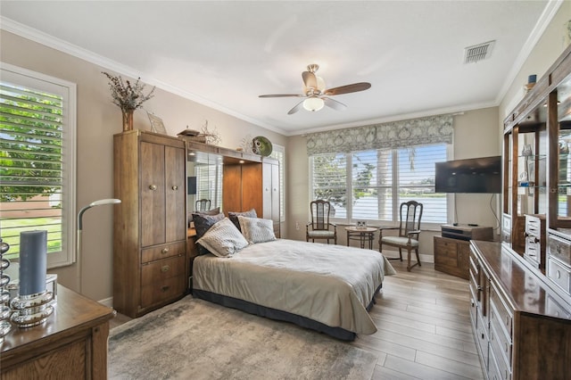 bedroom featuring ceiling fan, light hardwood / wood-style flooring, and crown molding