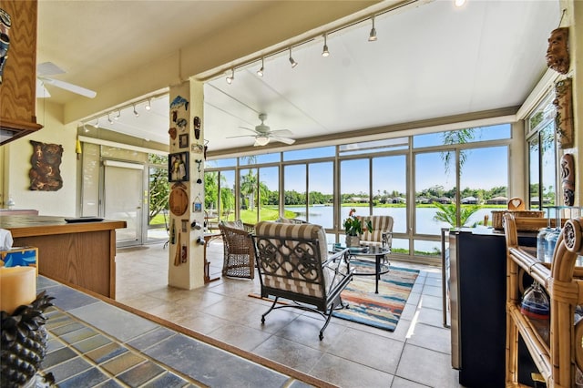 sunroom featuring a water view, ceiling fan, and track lighting