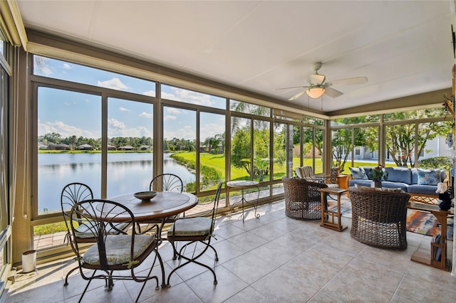 sunroom / solarium featuring a water view and ceiling fan